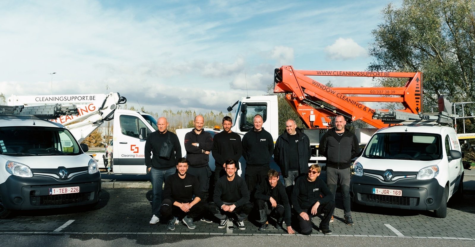 Het team van Cleaning Support met bestelwagens en hoogwerker